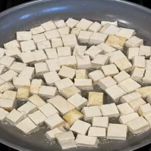 fry tofu cubes in pan